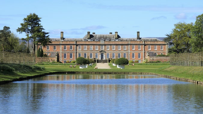 The 18th-century house at Erddig, viewed across the lake with the water in the foreground.
